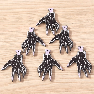 Macro detail of skeleton hand resin charms in black and purple for Halloween DIY crafts