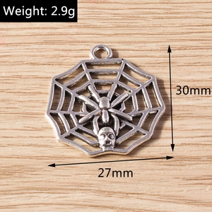 Macro view of silver spider web pendant with small skull detail for DIY jewelry