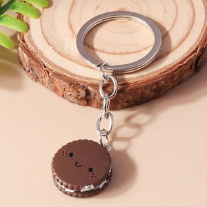 Macro view of chocolate cookie keychain with cartoon smile and silver metal ring