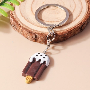 Detail of a chocolate ice cream keychain on a wooden stand with a silver keyring