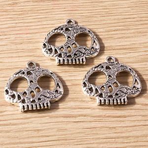 Detailed macro view of three hollow skull alloy pendants with intricate carvings