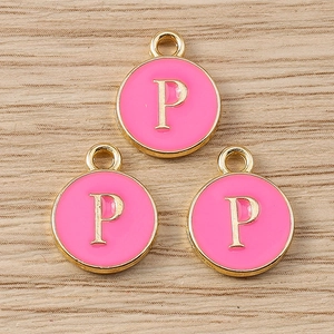 Close-up of pink enamel round charms with golden letter P for DIY jewelry making