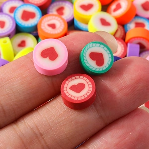 Makroaufnahme bunter flacher Herz-Polymer-Tonperlen für DIY-Bastelarbeiten und Schmuck