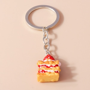 Detailed macro view of a 3D strawberry cake keychain with realistic cream layers