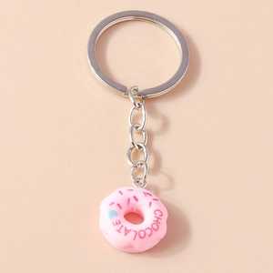 Detailed view of pink resin donut keychain with chocolate text on pastel background