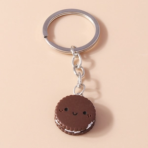 Detail of creative chocolate cookie keychain with cream filling and a cute smiley face