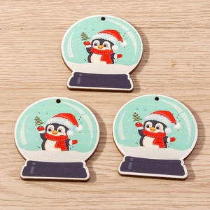 Detailed view of three penguin snow globe wooden ornaments with pre-drilled holes