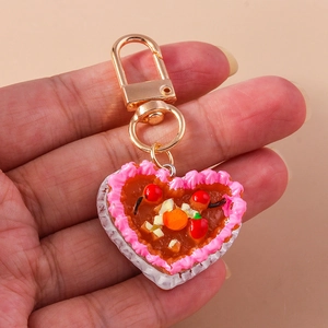 Detailed view of handmade heart cake keychain with realistic fruit slices and cream