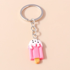 Detail of pink cartoon popsicle keychain with white icing drips and metal ring
