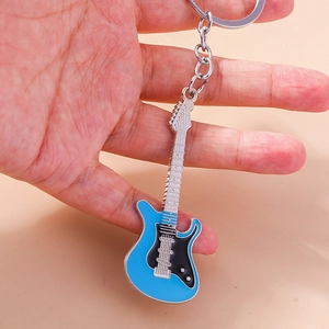 Detail of blue electric guitar keychain with metal ring and realistic string accents