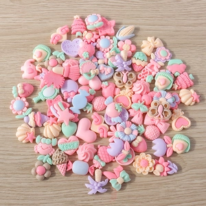 Draufsicht auf bunte DIY-Resin-Anhänger mit Blumen, Herzen und Tieren in sanften Pastelltönen