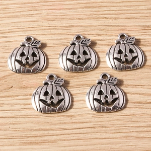 Detailed macro view of five hollow Jack-o'-lantern pumpkin alloy pendants for DIY jewelry