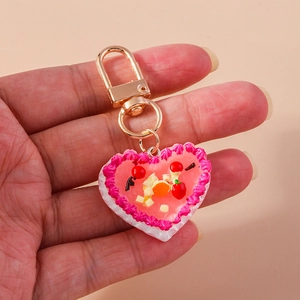 Realistic heart cake keychain with strawberry and cherry details on a golden metal hook
