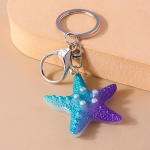 Detailed close-up of blue-purple gradient resin starfish keychain with silver lobster clasp