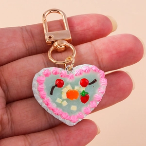 Blue heart-shaped fruit cake keychain with pink cream edges and golden metal clasp