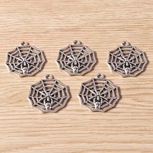 Detail view of five retro silver spider web pendants with skull accents for DIY jewelry