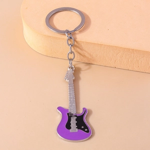Close-up of a purple electric guitar keychain with silver metal details and keyring