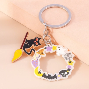Détail du pendentif chat noir en métal et du médaillon d'Halloween sur le porte-clés