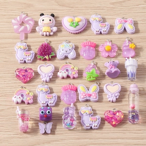 Macro view of colorful resin flower and fruit pendants with metal rings for DIY jewelry