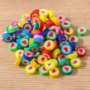 Makroaufnahme bunter Herzperlen aus Polymer-Ton mit Streifen für DIY-Schmuck