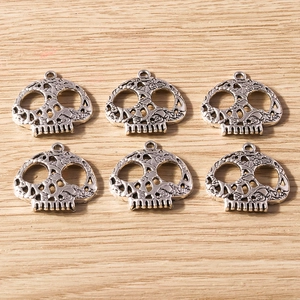 Set of six vintage silver alloy skull pendants with intricate hollow design for DIY jewelry