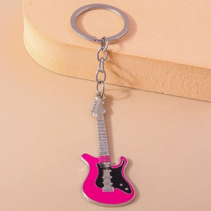 Close-up of stylish electric guitar metal keychain with pink enamel and silver chain