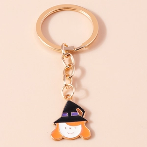 Détail du porte-clés en métal doré avec un charm de sorcière d'Halloween de dessin animé