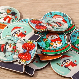 Detailed view of wooden Christmas snowball ornaments featuring snowman and penguin prints
