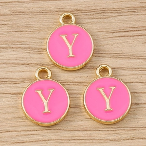 Detailed view of round pink enamel letter Y charms with golden metal frames for DIY