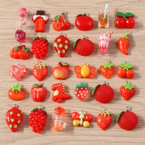 Macro shot of assorted red and orange resin fruit and heart charms for DIY jewelry making