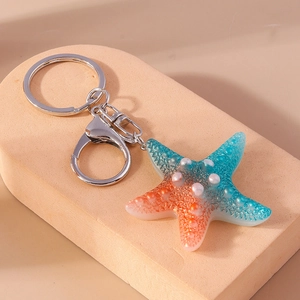 Detailed close-up of a resin starfish keychain with gradient colors and pearl accents