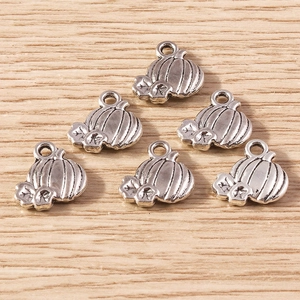 Detailed close-up of silver pumpkin alloy charms for DIY Halloween jewelry projects