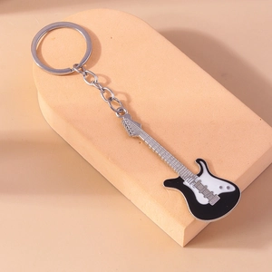 Macro shot of stylish black and white guitar keychain on an orange geometric background