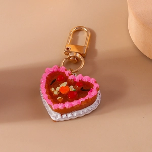 Close-up of heart-shaped chocolate fruit cake keychain with gold lobster clasp