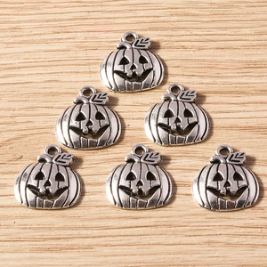 Set of six vintage silver Halloween pumpkin charms on natural light wood background