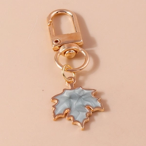 Detailed close-up of rose gold maple leaf keychain with grey marble glaze effect