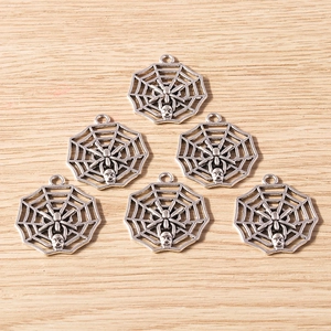 Detailed view of silver alloy spider web pendants with skulls for DIY jewelry making