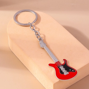 Detail of red electric guitar keychain featuring metallic strings and black enamel finish