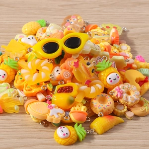 Close-up of assorted yellow cartoon resin charms for DIY jewelry making with metal rings