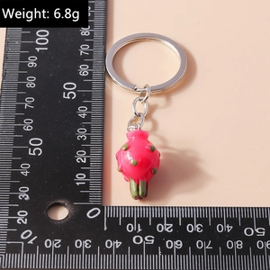 Macro detail of pitaya keychain with dimensions and 6.8g weight on pink background