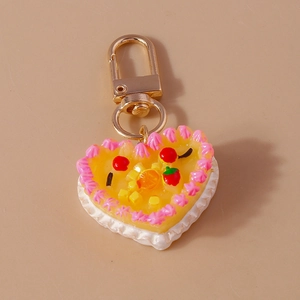 Top view of creative heart-shaped cake keychain with cream and realistic fruit details