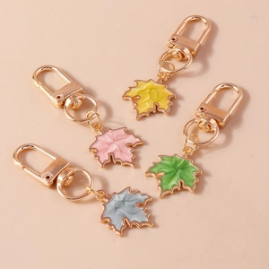 Set of four stylish maple leaf keychains in vibrant colors with gold metal hooks