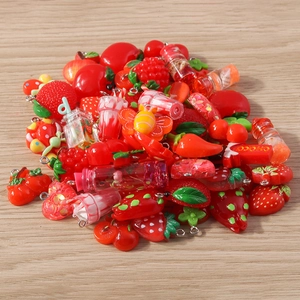 Macro shot of assorted red resin fruit and food charms for DIY jewelry making
