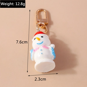 Llavero de muñeco de nieve con gorro rojo mostrando las dimensiones de 7,6 cm de alto