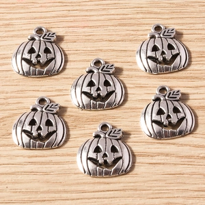 Set of 6 antique silver pumpkin pendants for DIY Halloween jewelry on wood background