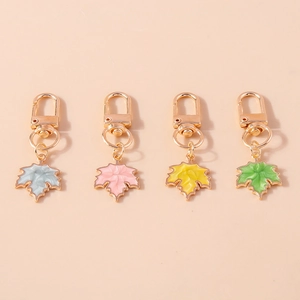 Set of four colorful maple leaf keychains with gold finish and enamel details