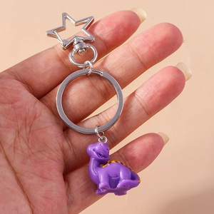 Cute purple cartoon dinosaur keychain with a silver star-shaped metal clasp for backpacks