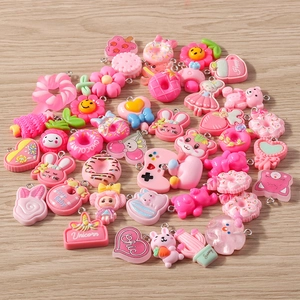 Detailed close-up of pink resin charms with heart, rabbit and flower shapes for DIY jewelry