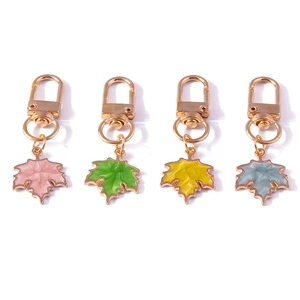 Set of four colorful maple leaf keychains with gold lobster clasps on a white background