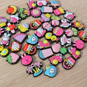 Flache Draufsicht auf bunte Comic-Resin-Anhänger mit Tieren und Früchten für DIY-Basteln